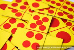 Red & yellow domino cards messily scattered on table 0yX61G