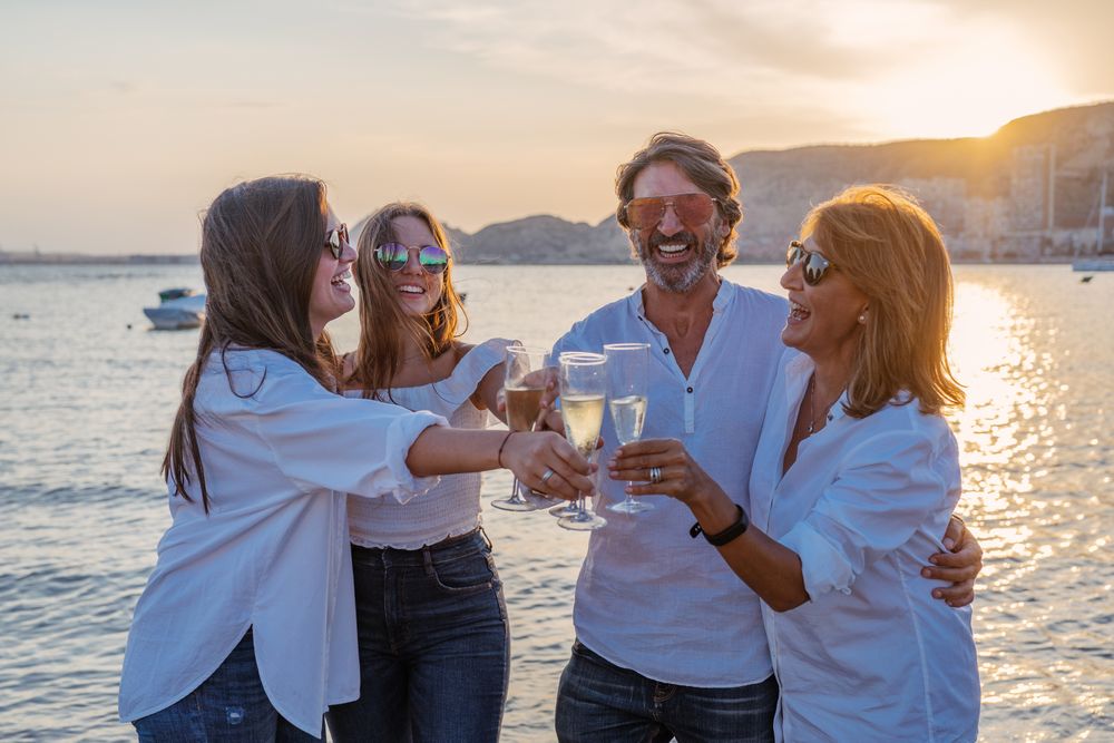 Happy family drinking wine on beach