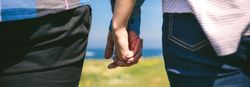 Unrecognizable couple holding hands