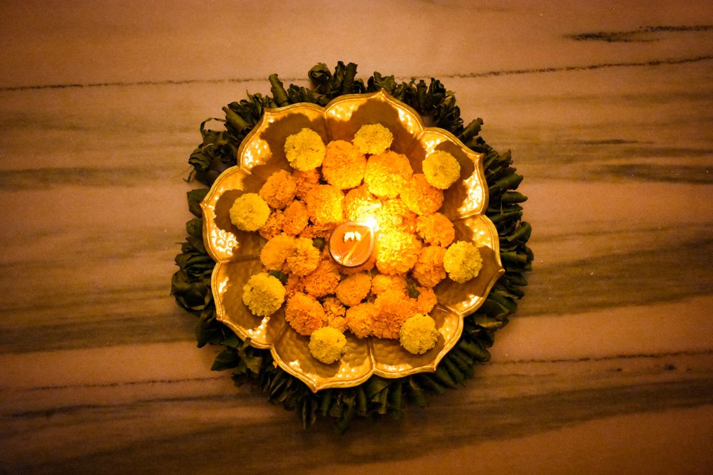 Top view of marigold flowers surrounded by Diya on tray