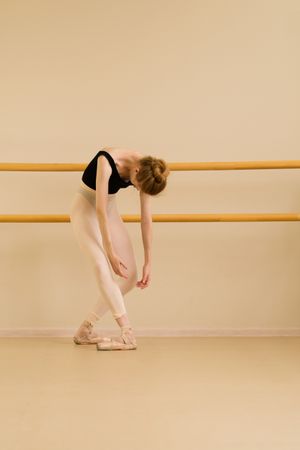 Ballet dancer leaning forward with arms hanging