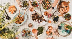 Flat-lay of peoples hands with glasses of rose wine over table