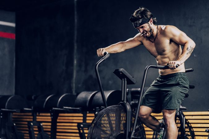 Hardworking male working out on gym bike