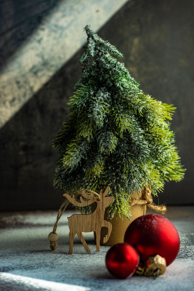 Christmas card concept of mini tree with bauble and reindeer ornament
