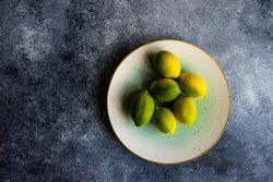 Plate of lemons at different levels of ripeness