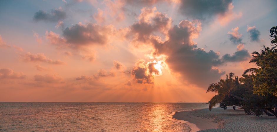 Peach tones in a sunset over the Indian Ocean from a beach, wide
