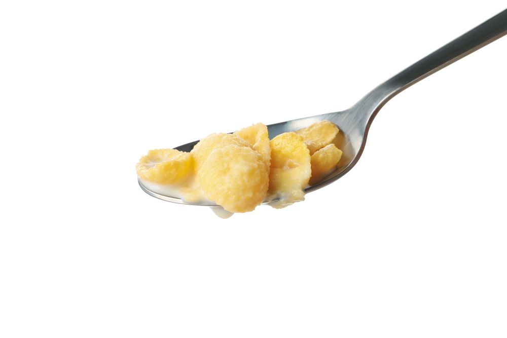 Spoon with muesli and milk isolated on plain background