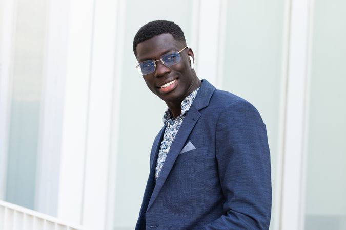Content Black businessman listening to music in earbuds in city