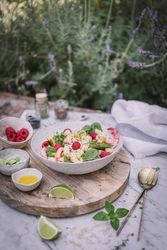 Tasty salad on wooden stand served on decorated table outside