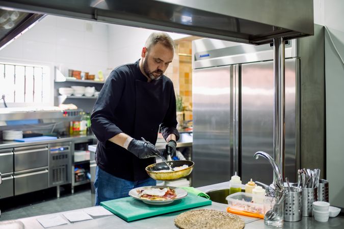 Male chef serving fried food in kitchen