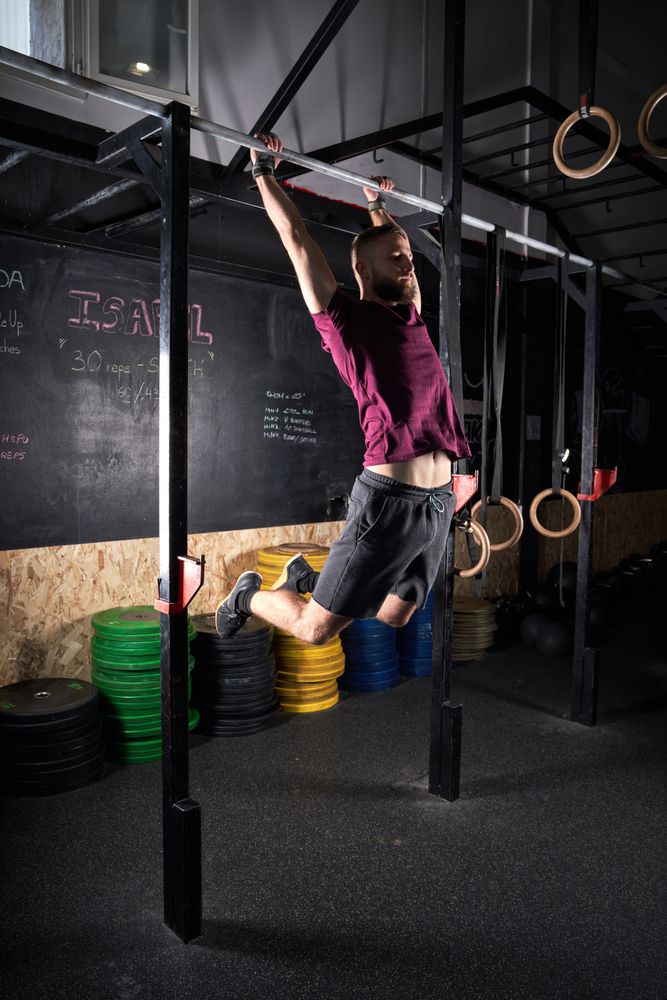 Sportsman doing pull ups in gym