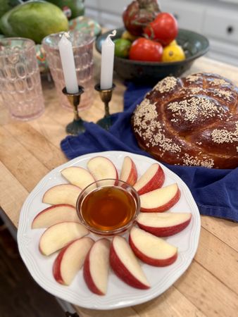 Apples and honey with challah and candles for a festive high holiday celebration