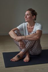Thoughtful woman resting after yoga lesson in gym