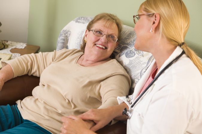 Doctor or Nurse Talking to Sitting Older Woman