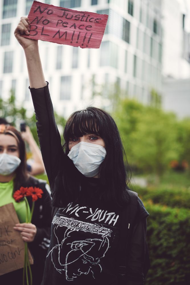London, England, United Kingdom - June 6th, 2020: Young woman holding “No Justice No Peace” sign