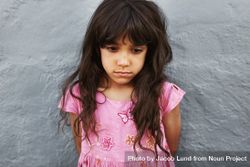 Close up portrait of little girl standing looking upset bYGx65