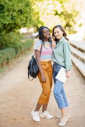 Female friends in casual clothing in park walk path