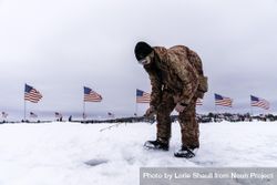 Nisswa, MN, USA - January 25th, 2020: A man ice fishing dressed in camouflage 4mZPvb