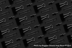 Binder clips and tacks on a dark background 5kGO65
