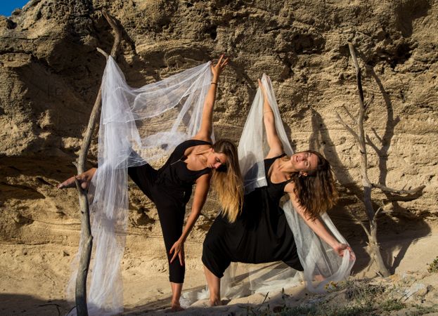 Women with textile dancing near stones