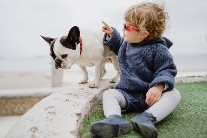 Funny kid with dog on beach