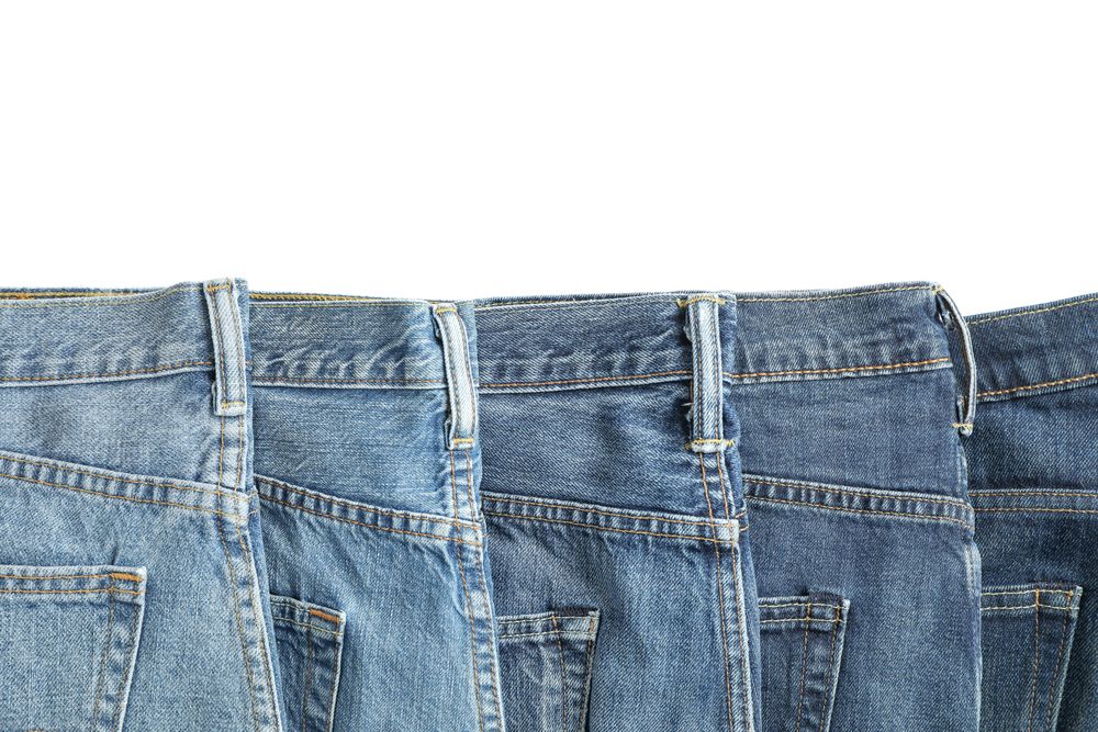 Jeans of different colors isolated on light background, space for text
