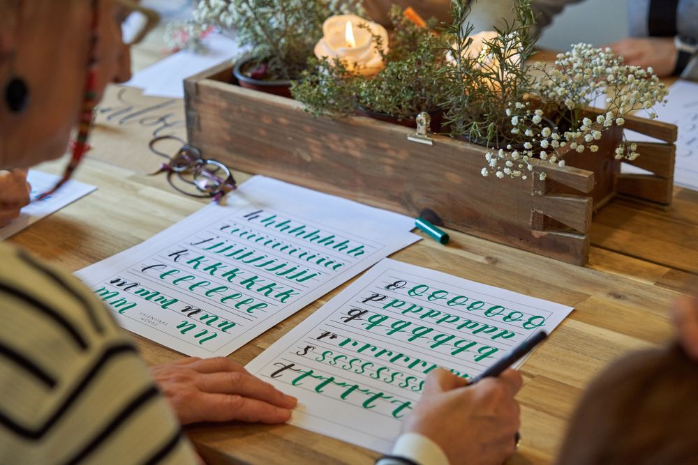 Woman writing letters with calligraphic handwriting at class