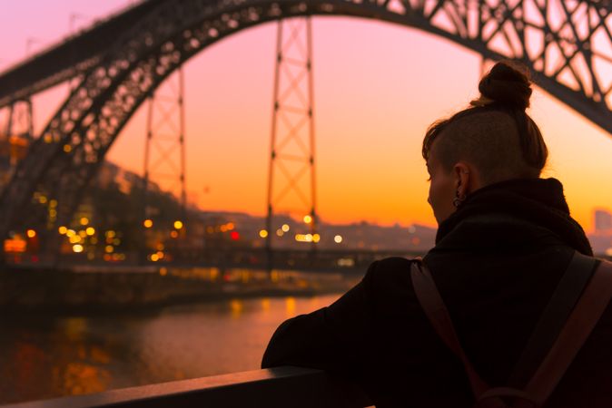 Woman looking at river and city in evening
