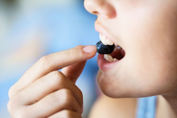 Girl biting into berry