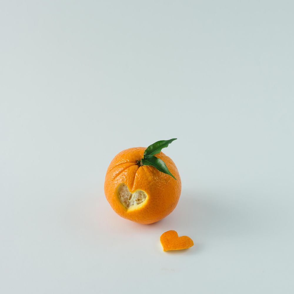 Orange with heart shaped cutout on  table
