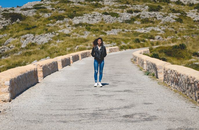 Woman standing on stony path in countryside