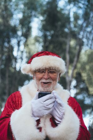 Happy Santa Claus with smartphone