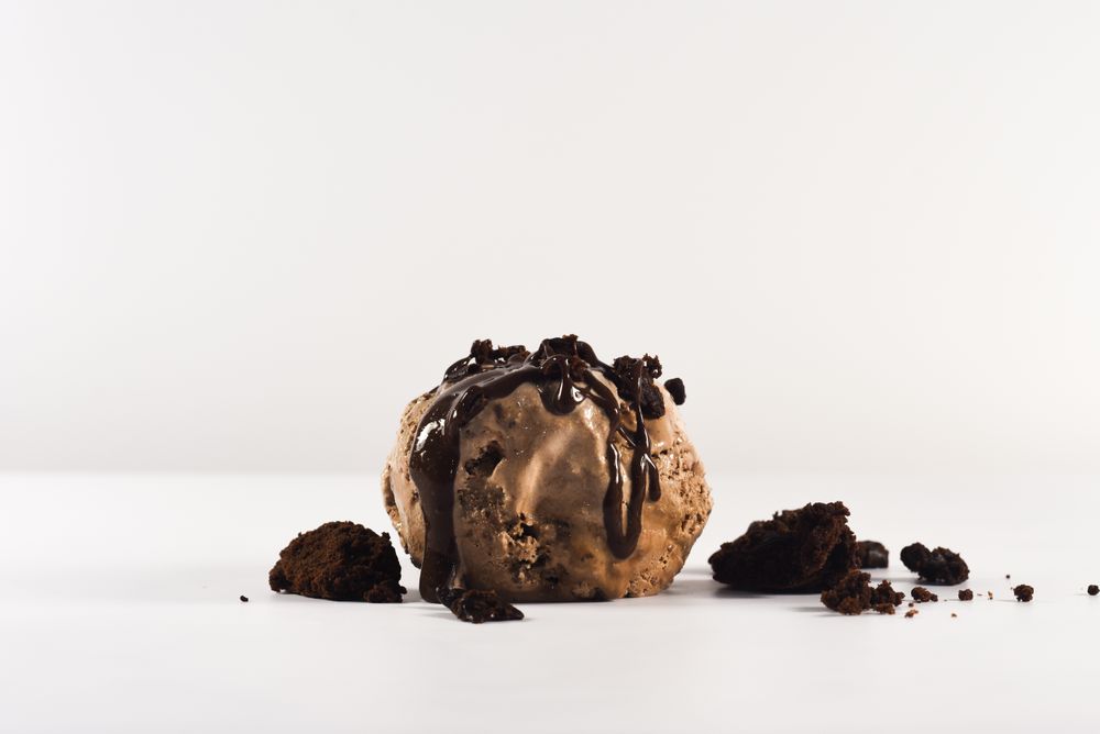 Scoop of chocolate ice cream with chunks of brownies