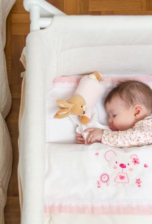 Baby girl sleeping with pacifier and toy