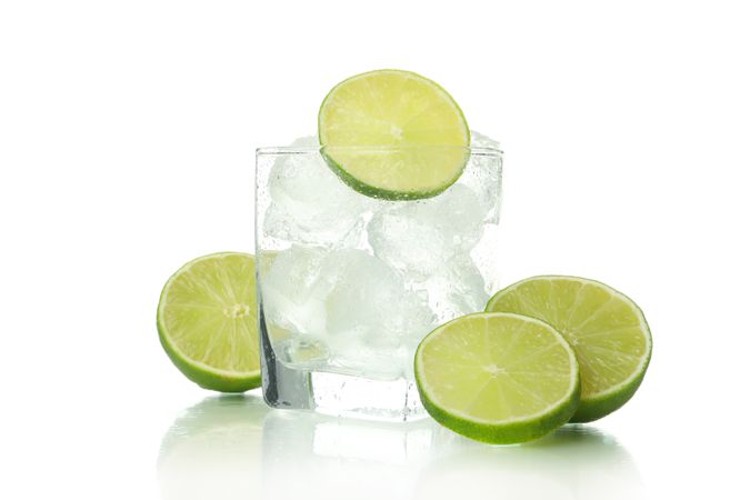 Rocks glass full of ice with lime halves