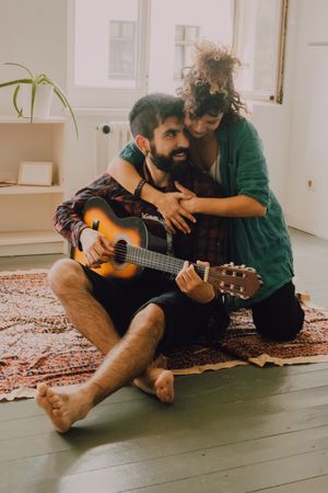 Cheerful couple playing guitar
