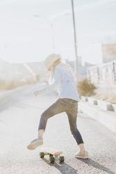 Stylish girl with skateboard on street