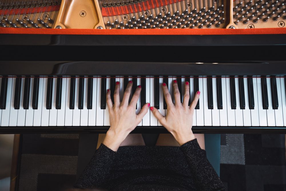 Top view of cropped hands playing the piano