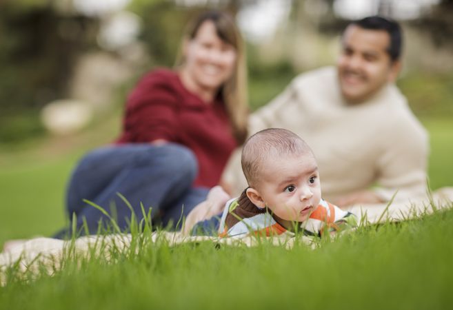 Happy Baby Boy and Parents Playing in Park