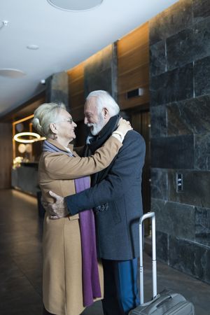Older couple embracing near hotel elevators
