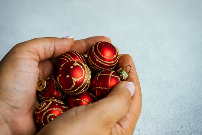 Christmas scene of hand holding red baubles