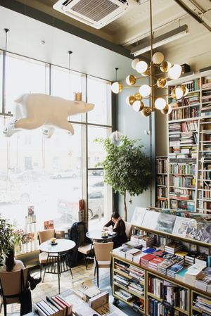 People sitting at tables in a coffee shop with bookstore
