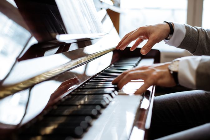 Crop male hands playing piano