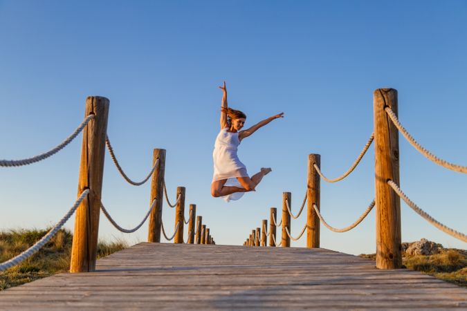 Woman posing in air on footbridge