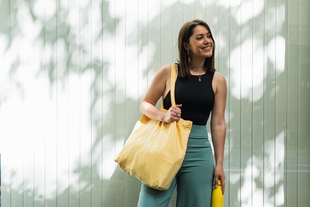 Happy woman with eco friendly bag in city