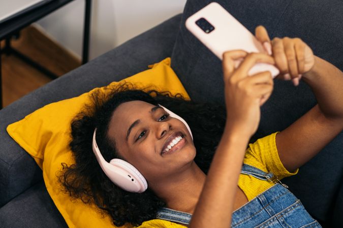 Relaxed Black woman, music & phone