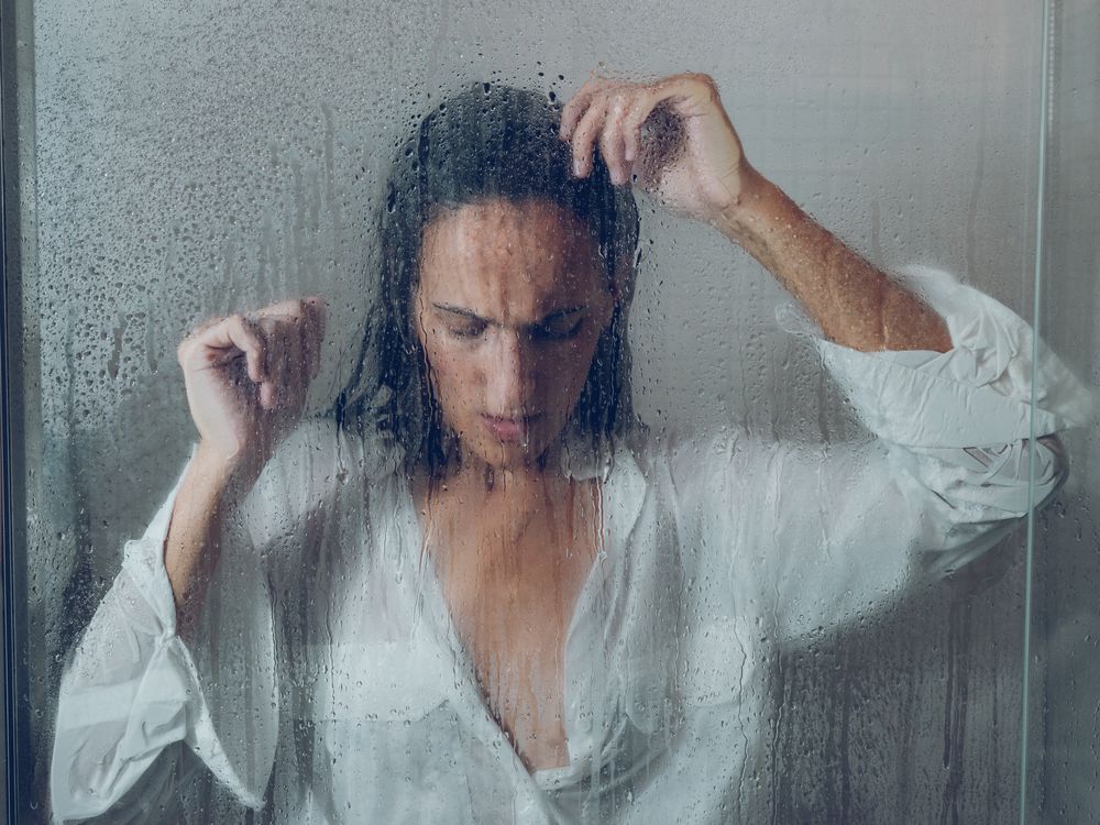 Unpleasant woman near wet glass door