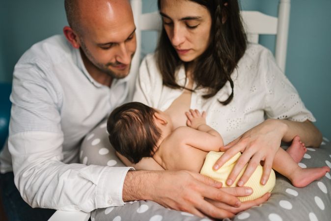 Happy parents feeding baby