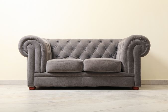 Simple interior with sofa against light beige wall