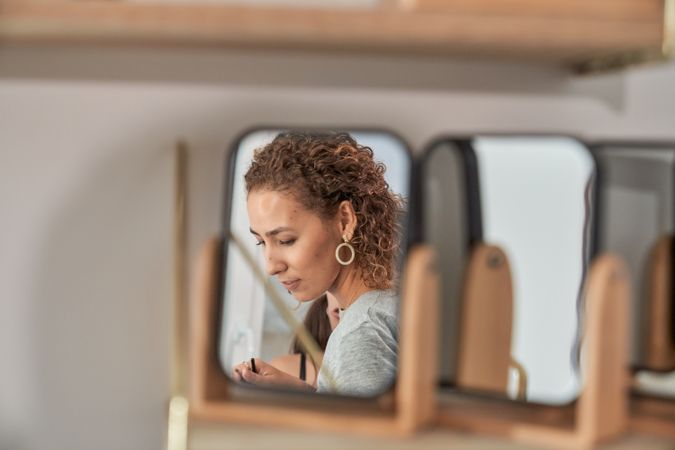Woman reflecting in mirror in studio
